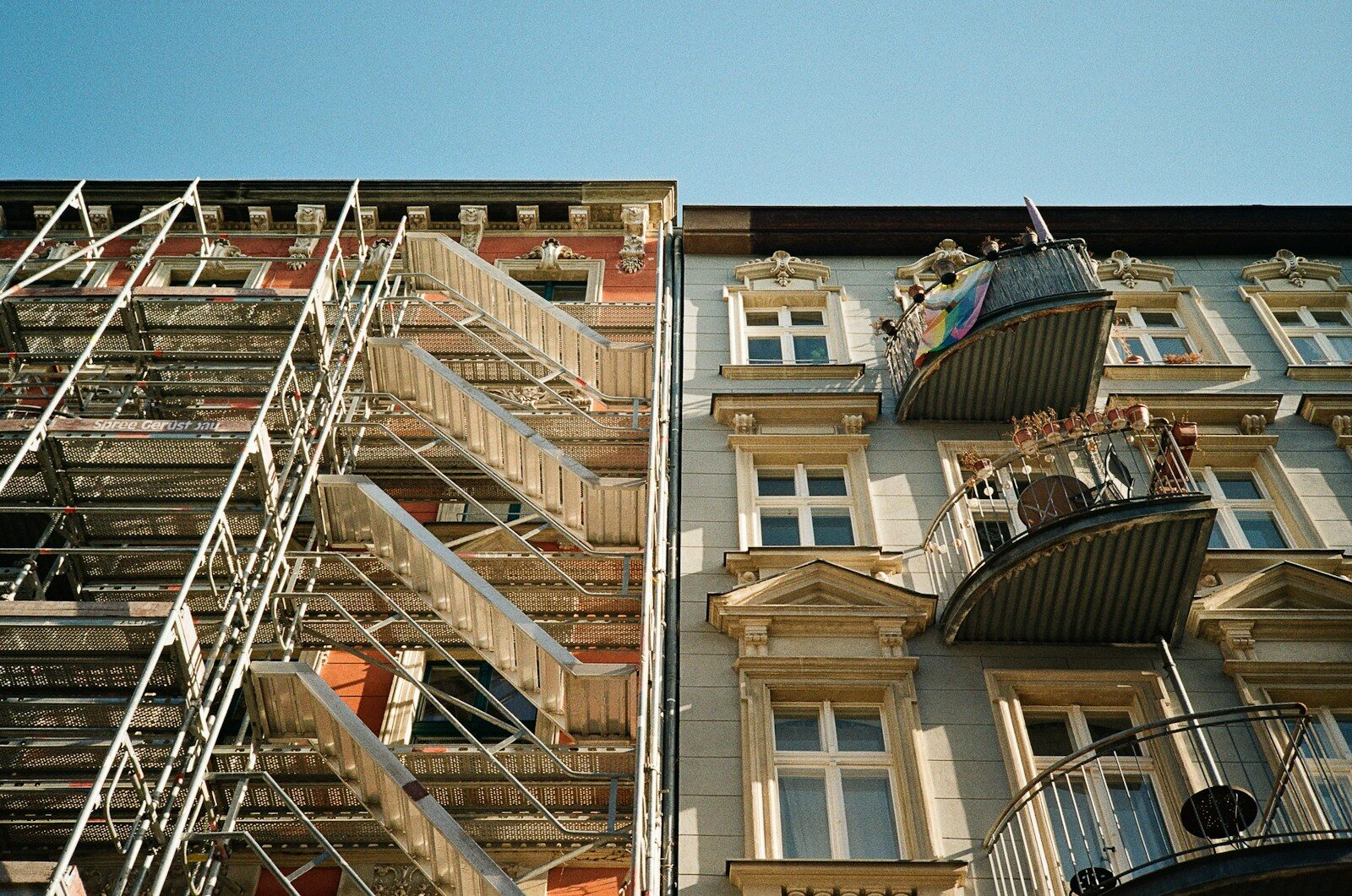 Two apartment buildings with fire escapes and balconies.