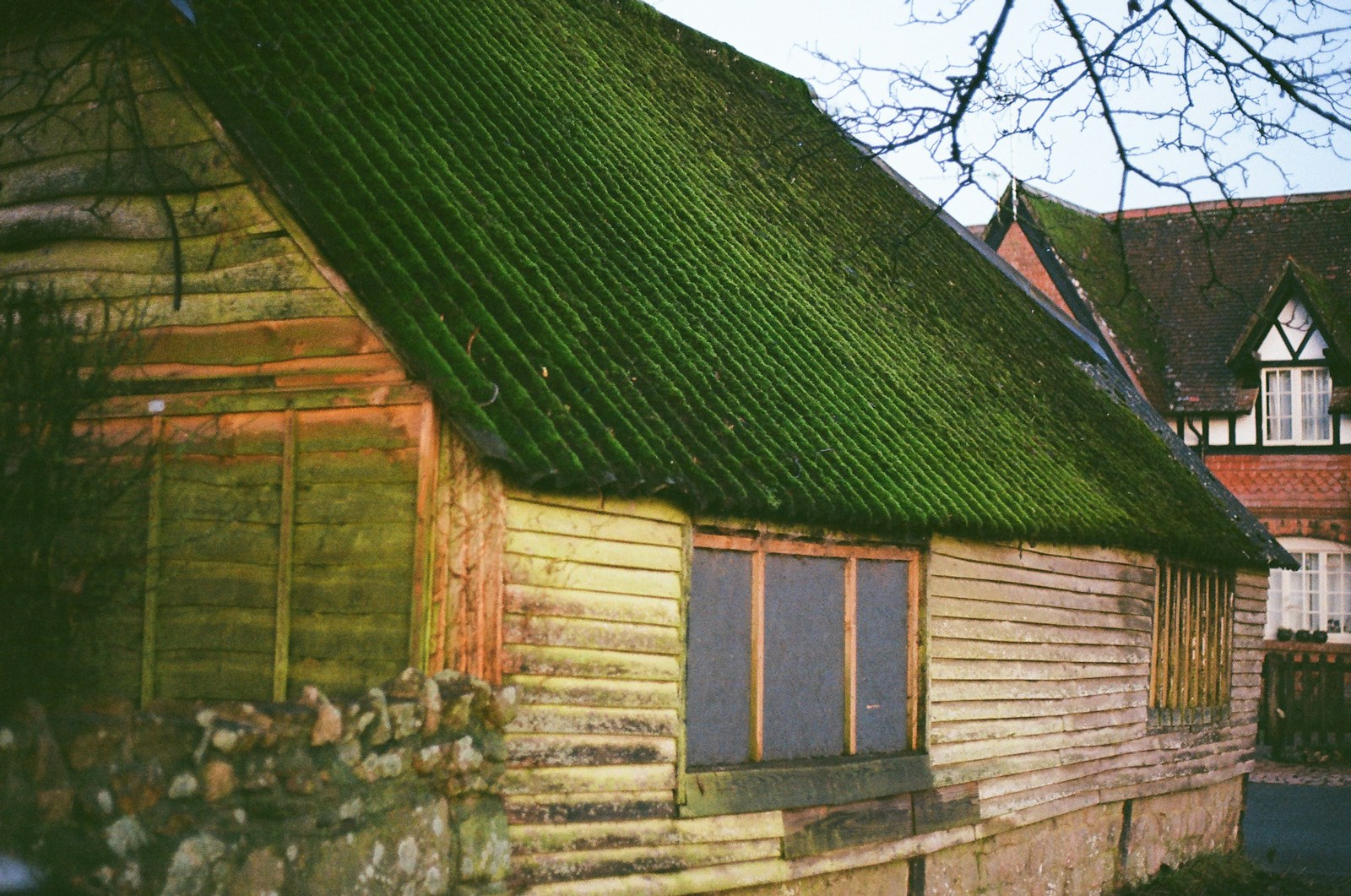 Old wooden barn with a mossy green roof